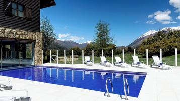 Una piscina techada, sillones reclinables de piscina