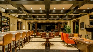 Un vestíbulo espacioso con zona de bar, asientos y chimenea.