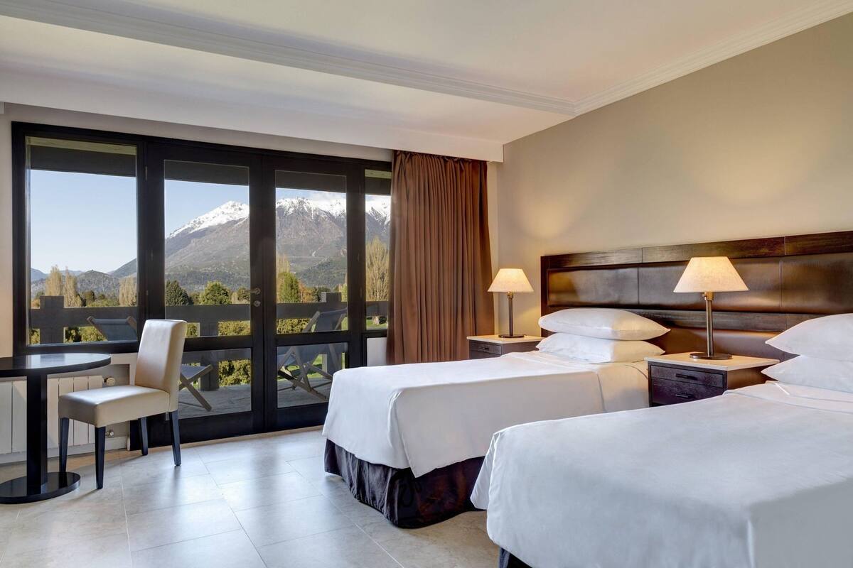 Una habitación de hotel con dos camas, un escritorio y una silla.