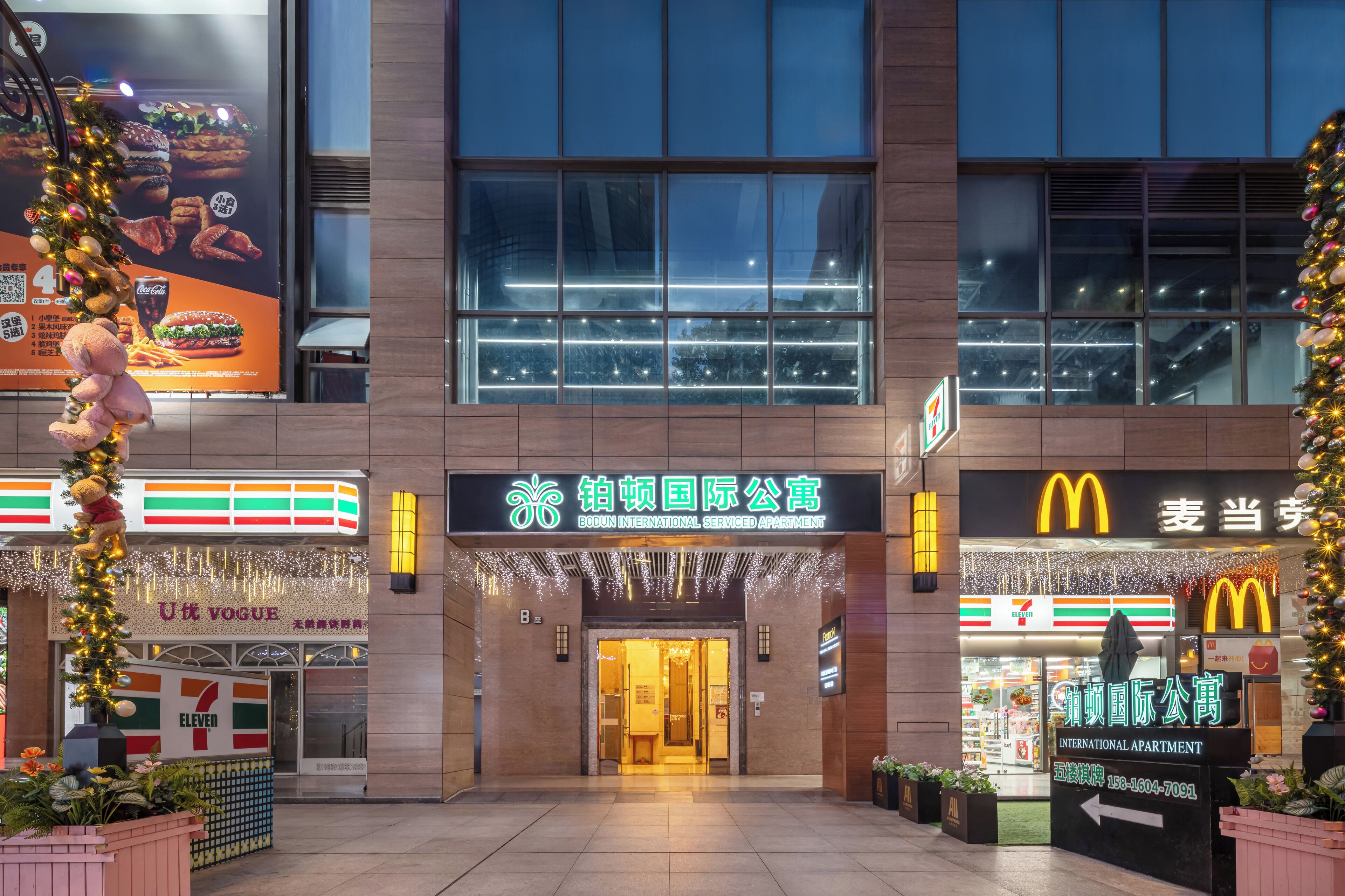 Entrada de un hotel con una tienda 7-Eleven y un McDonald’s al otro lado de la calle.