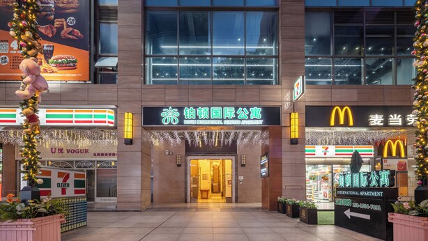 Ein Hotel Eingang, gegenüber liegt ein 7-Eleven und ein McDonald's.