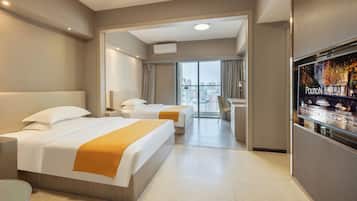 Quarto de hotel com duas camas, televisão e vista para a cidade.