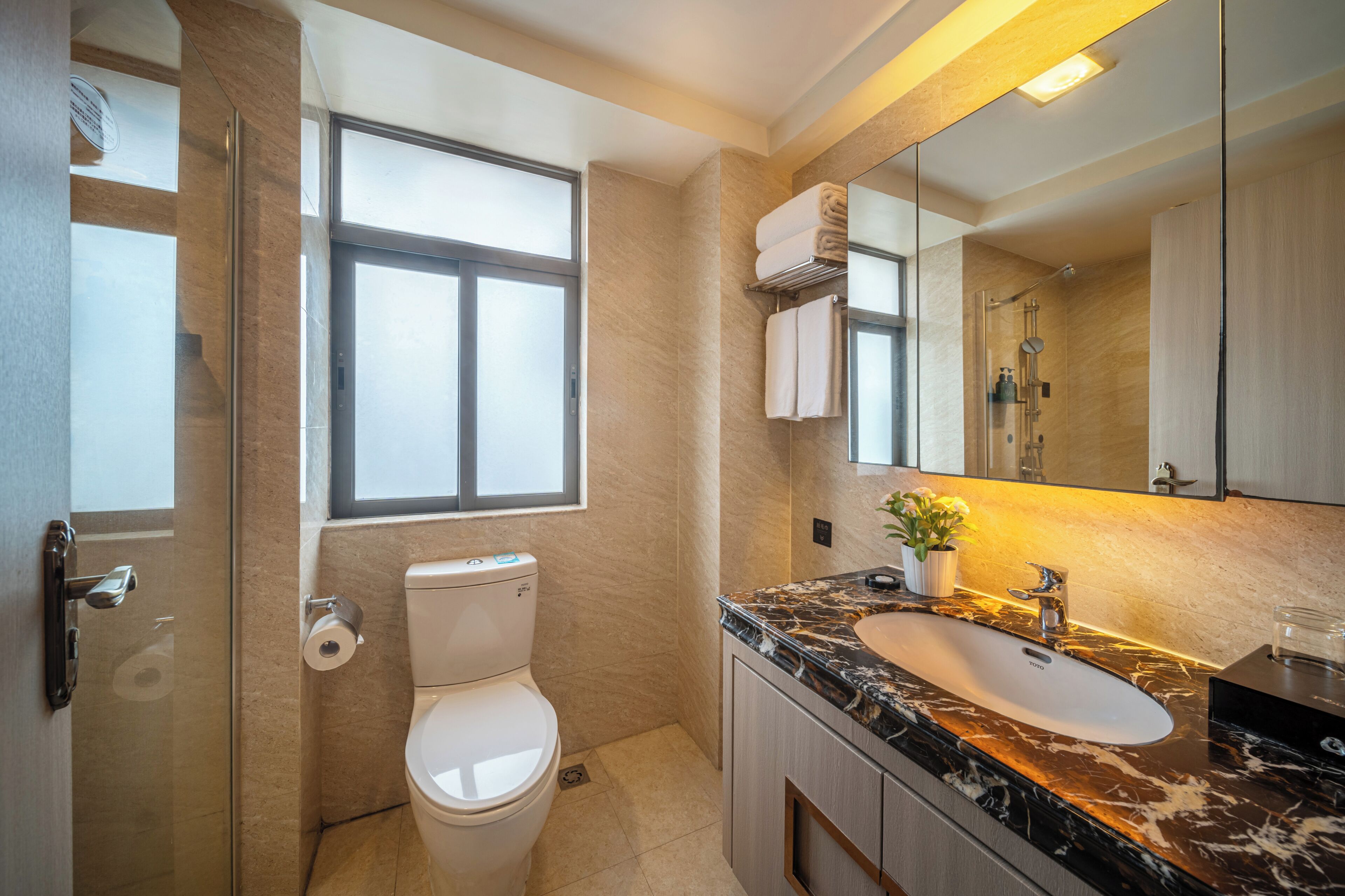 Un baño moderno con inodoro, lavabo y ducha.