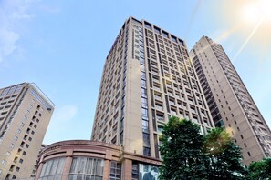 A high-rise building with multiple floors and a central core, surrounded by other tall buildings. - Poltton International Apartment (Foshan Zumiao Lingnan Tiandi Branch) (Foshan)