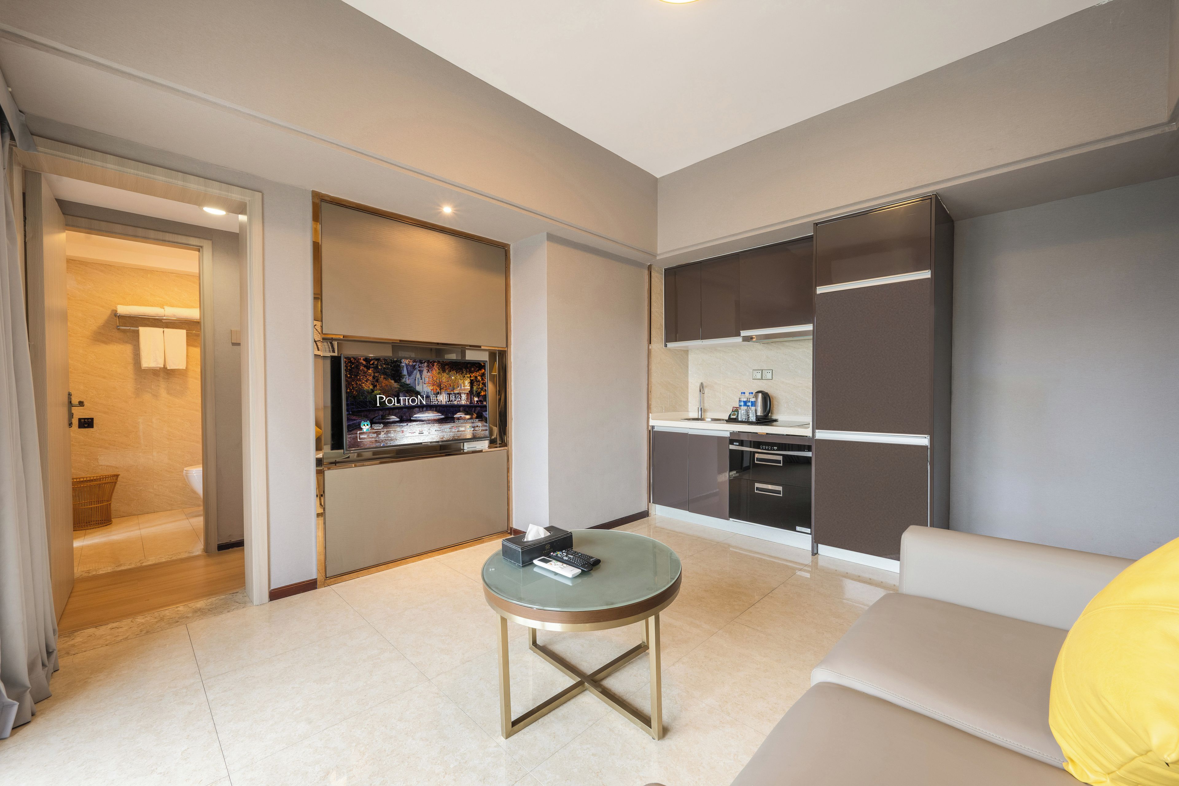 Una habitación de hotel moderna con sala de estar, cocina y baño.