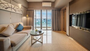 Una sala de estar moderna con un sofá, una mesa de centro de vidrio y un televisor.