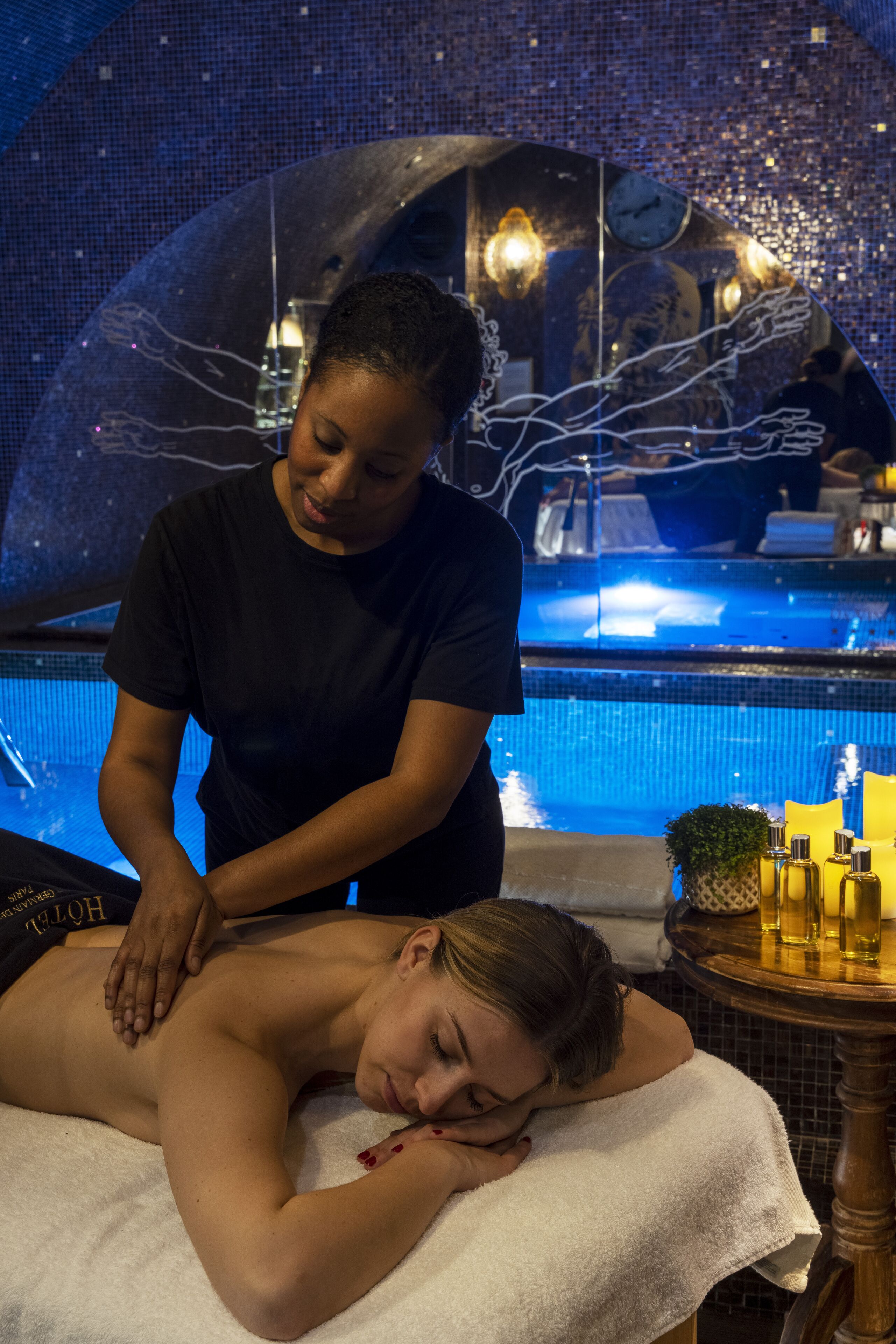 A person receiving a massage by a poolside.