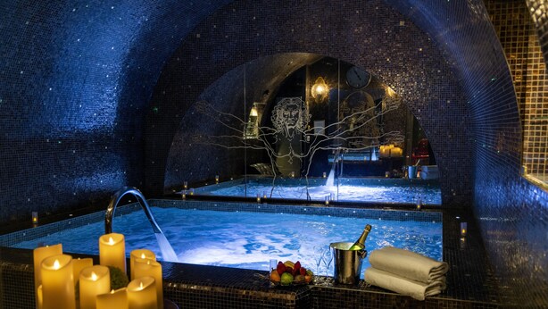 Un área de spa con dos jacuzzis, velas y un frutero.