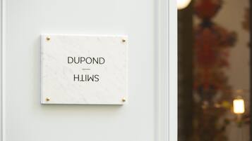 A marble plaque with the text "DUPOND" and "HILWS" on a white wall.