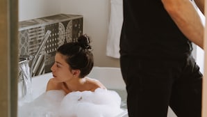 A bathroom with a bathtub, a towel rack, and a mirror. - Hôtel Dupond Smith (Paris)