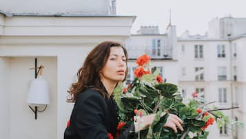 A person sitting on a rooftop with a potted plant.