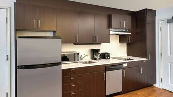 Una cocina moderna con armarios de madera oscura, electrodomésticos de acero inoxidable y lavavajillas.