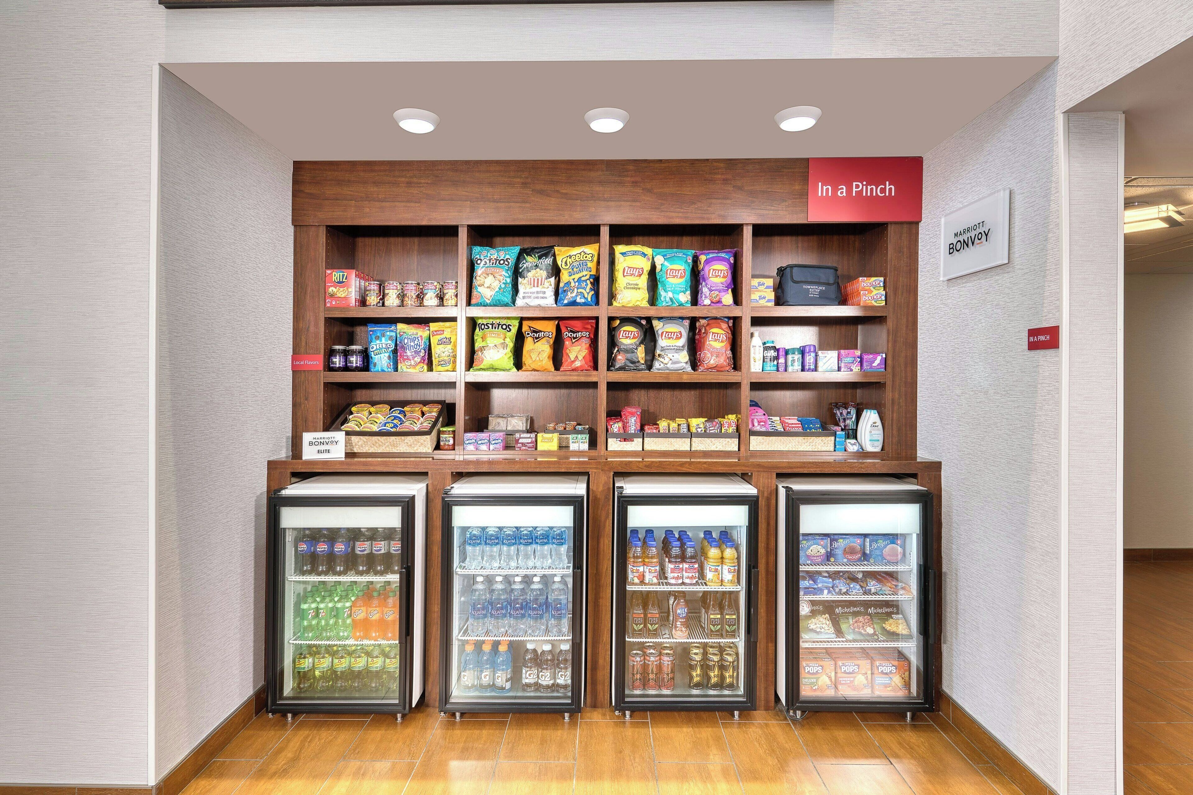 A snack display with various chips and a refrigerated section with beverages.