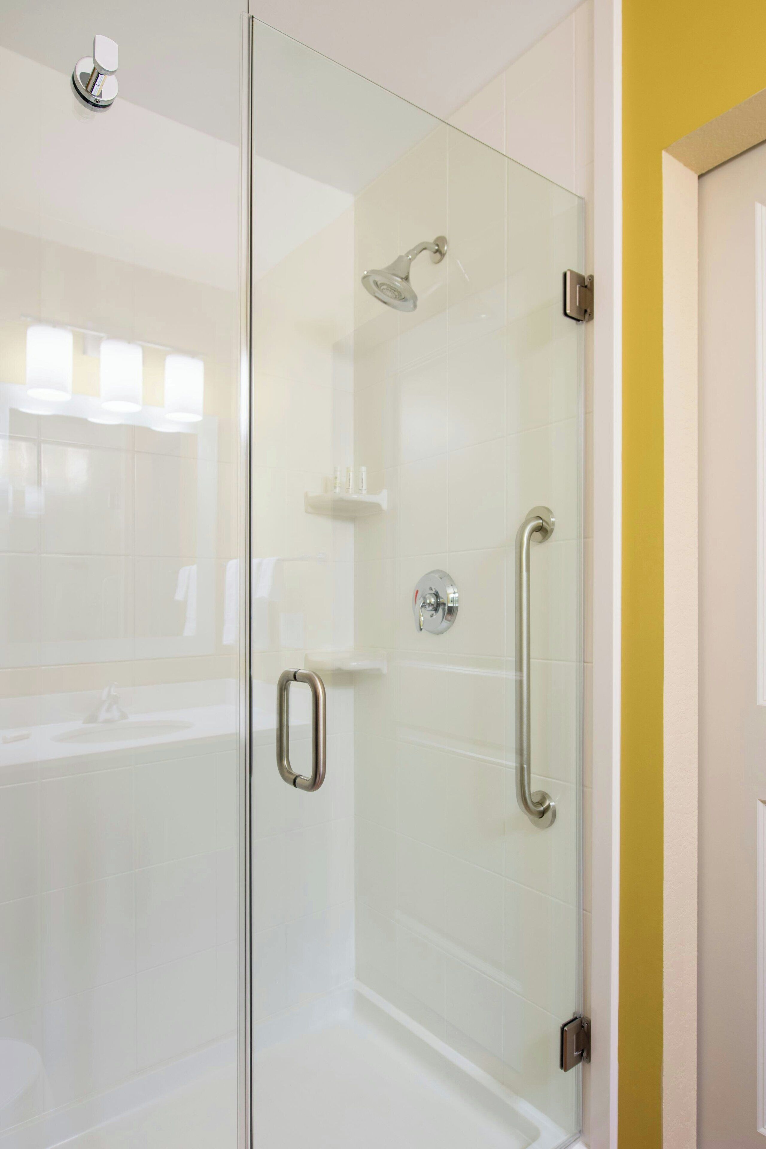 A modern bathroom with a glass-enclosed shower, a white sink, and a toilet.