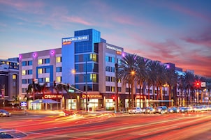 Un hotel SpringHill Suites Marriott con un diseño moderno, una farmacia CVS y una calle concurrida con estelas de luz.