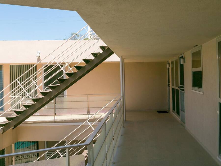 Un pasillo con una escalera que conduce a un nivel superior.