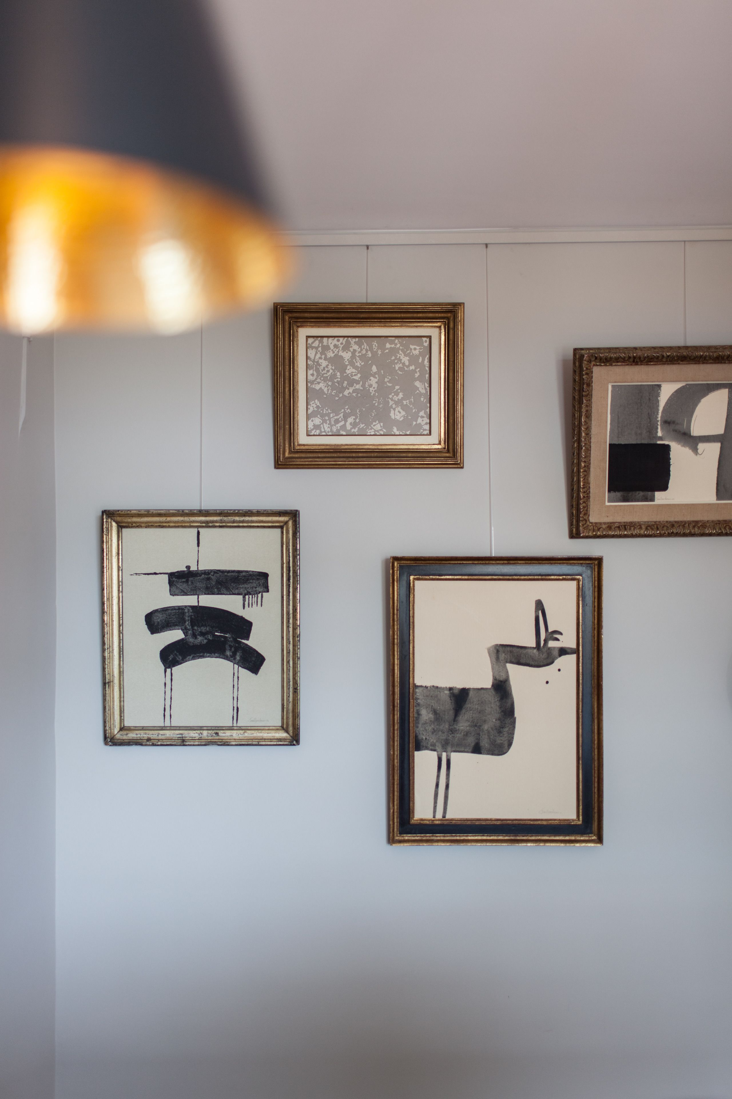 Eine Wand mit vier gerahmten Kunstwerken.