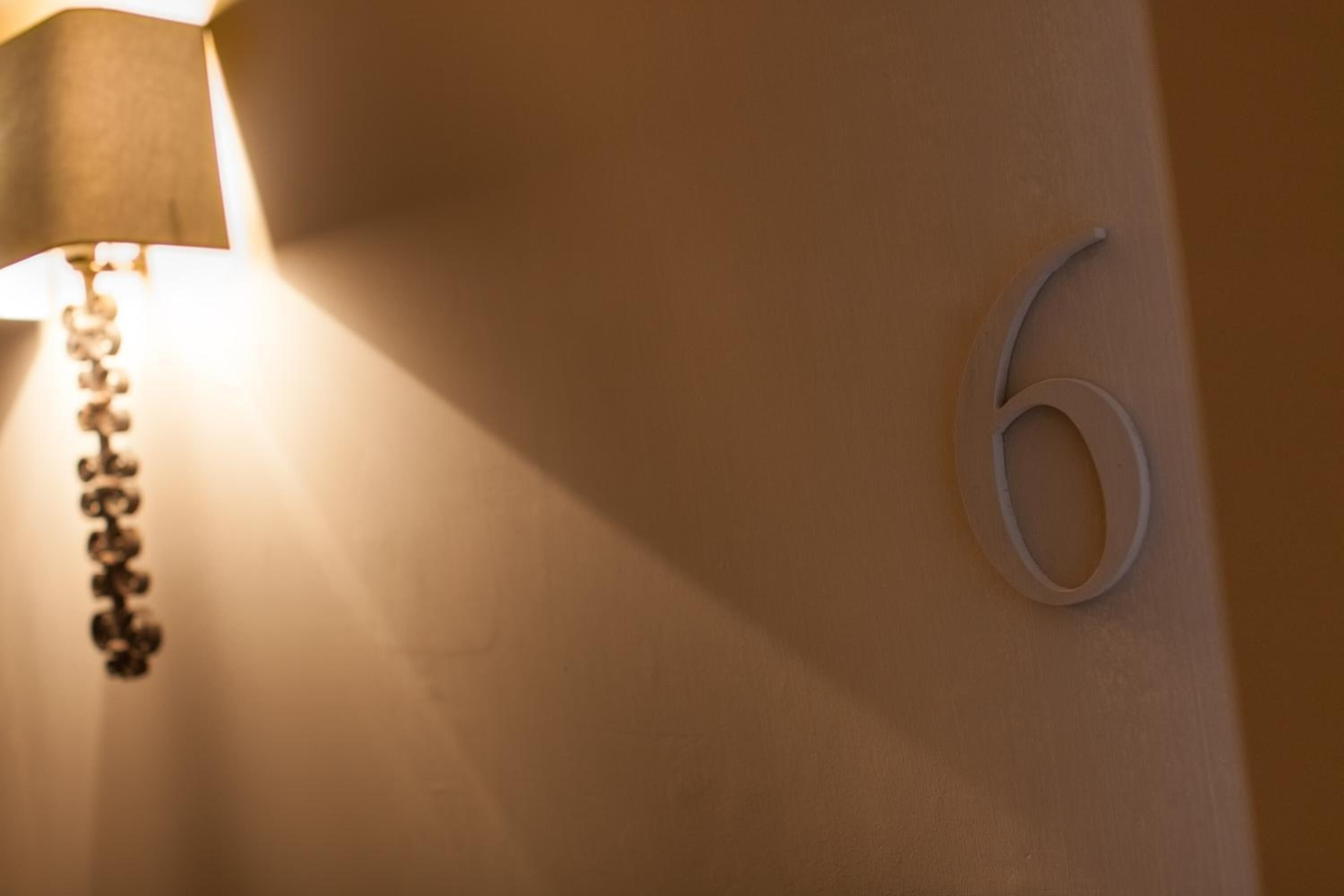 A wall with a number '6' and a lamp with a chain.