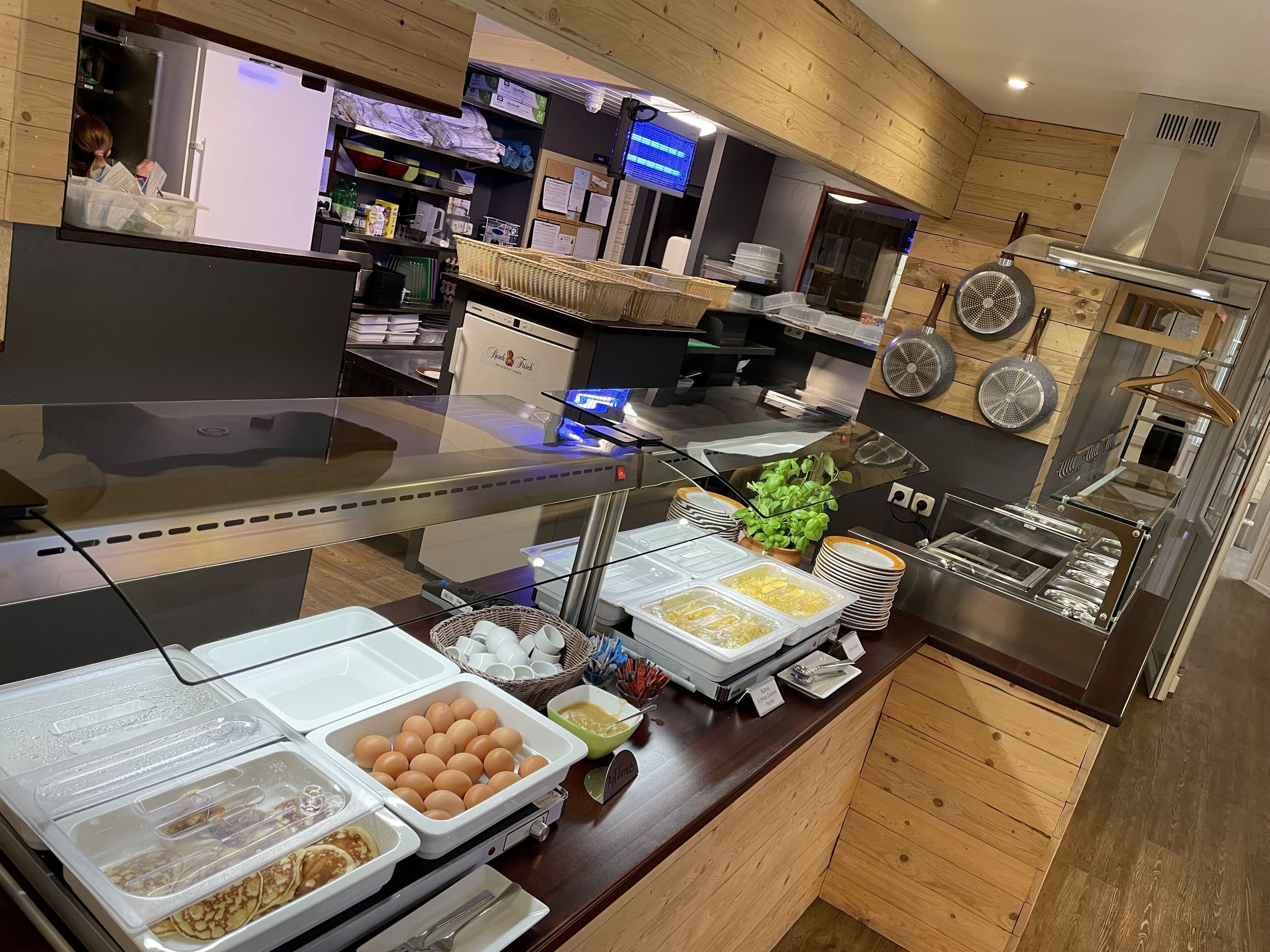 A buffet area with various food items and a kitchen in the background.