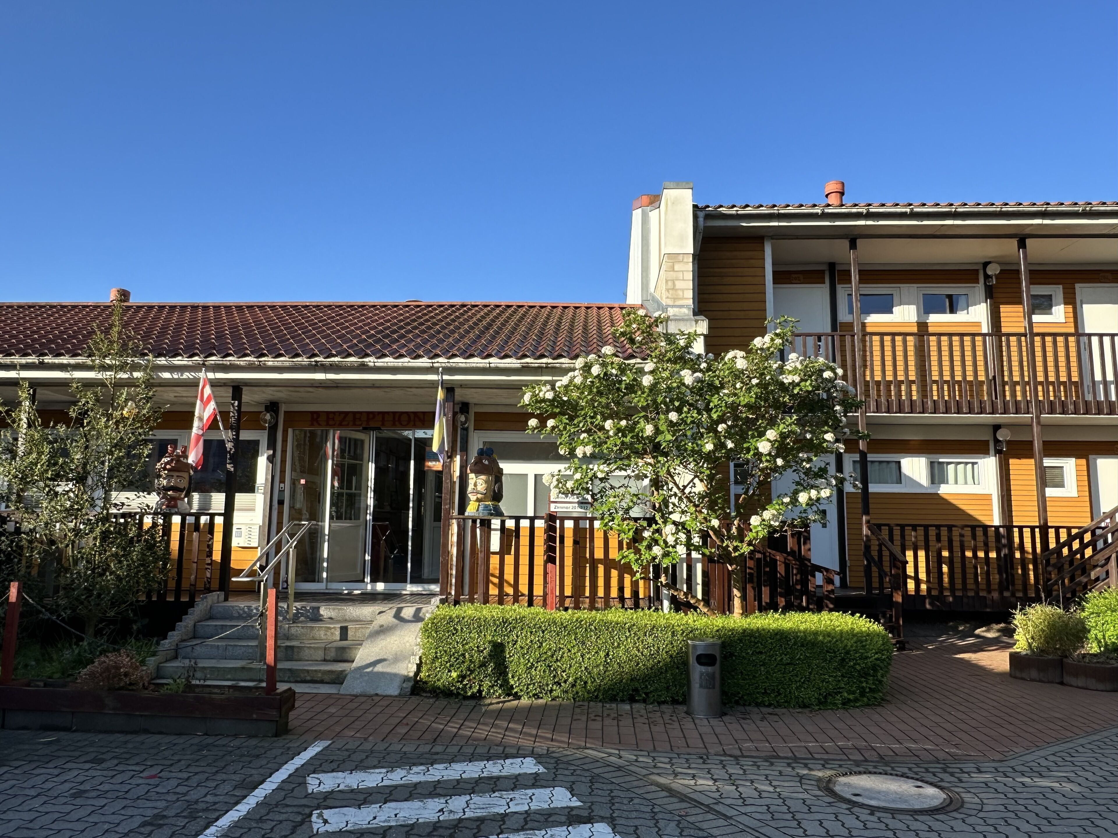 A hotel with a reception area, a staircase, and a balcony.
