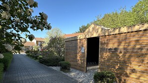 Een geplaveid pad dat leidt naar een houten gebouw met een open ingang.