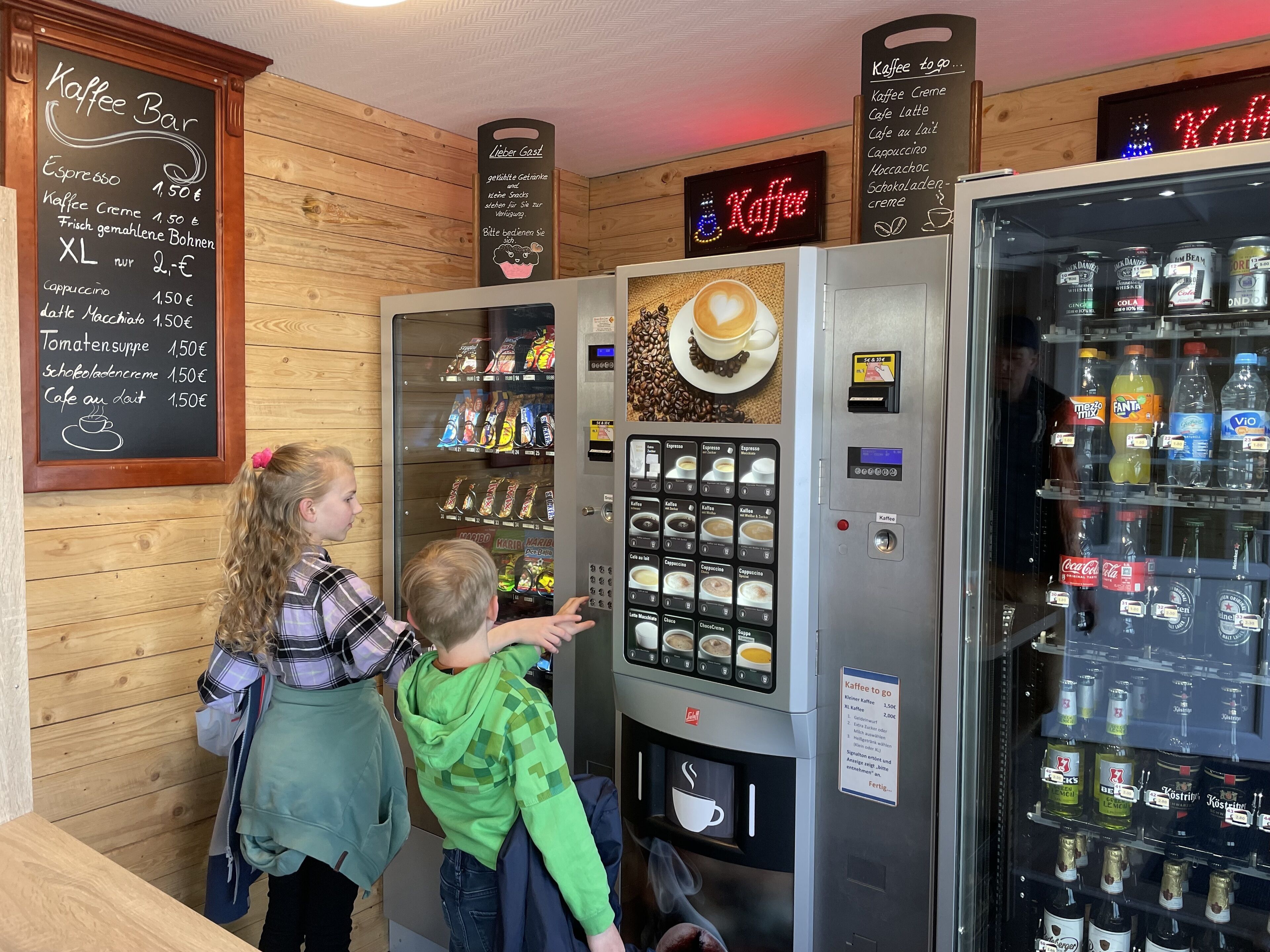Een koffiebar met een menubord en een automaat voor drankjes.
