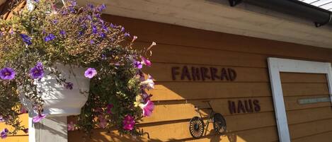 A building with a sign reading "FAHHRRAD HAUS" and a bicycle mounted on the wall.