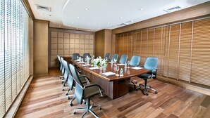 A conference room with a long table, multiple chairs, and a wooden paneled wall. - The Lalit Traveller Jaipur (Jaipur)