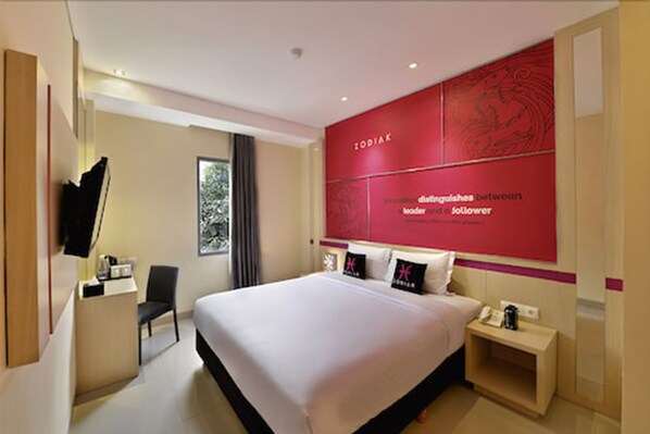 A modern hotel room with a large bed, a desk, a chair, and a TV. - Zodiak Kebon Kawung by KAGUM Hotels (Bandung)