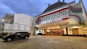 Un hotel con un cartel grande que dice "ZODIARK HOTEL" y una camioneta negra estacionada frente a él.