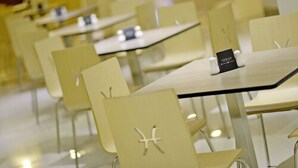 Un comedor moderno con sillas y mesas blancas, con un diseño sencillo y minimalista.