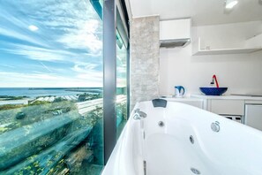 Chambre, baignoire à jets, vue océan | Matelas Tempur-Pedic, coffres-forts dans les chambres