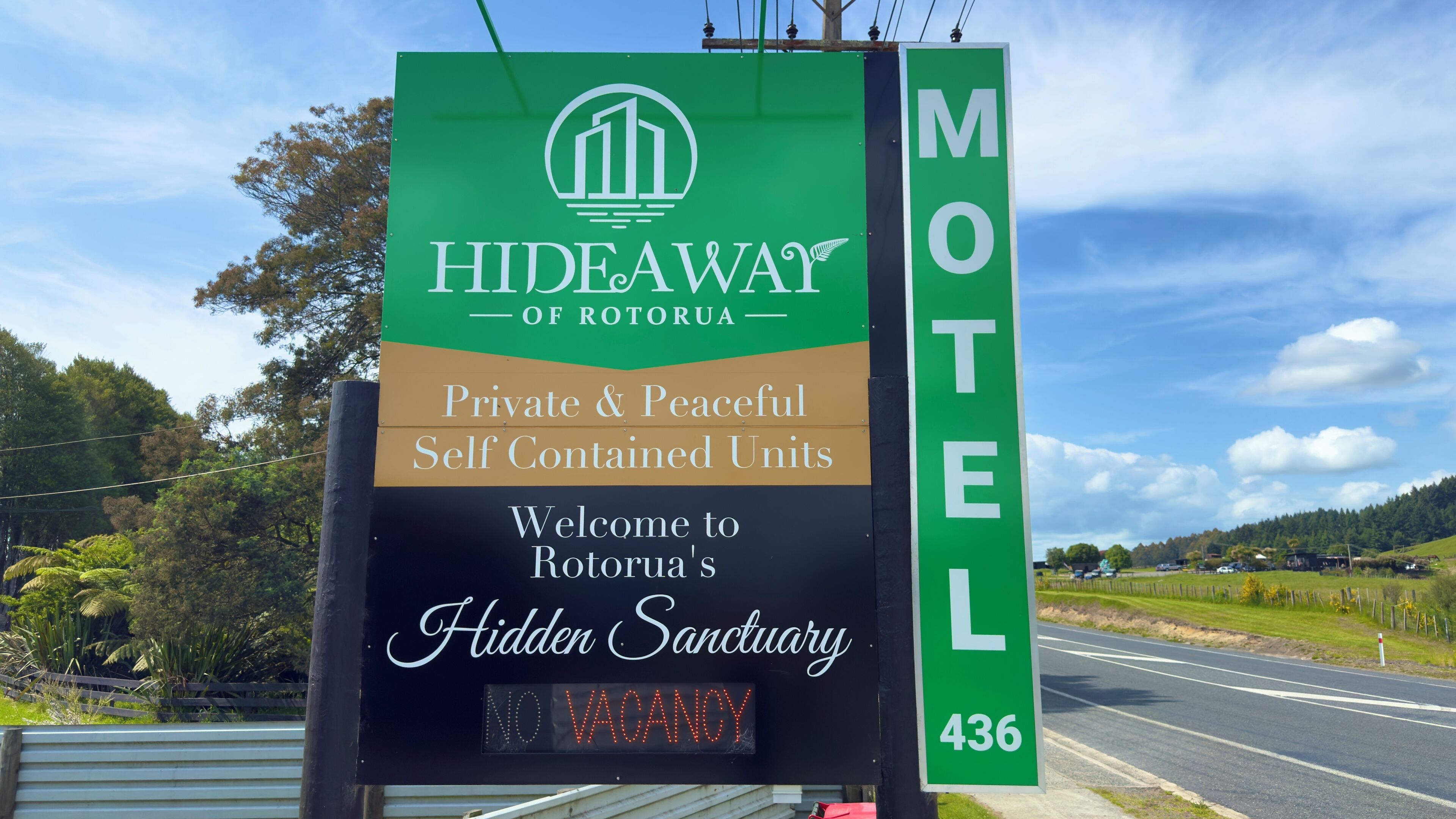 A motel sign with a green and black color scheme, indicating private and peaceful self-contained units.