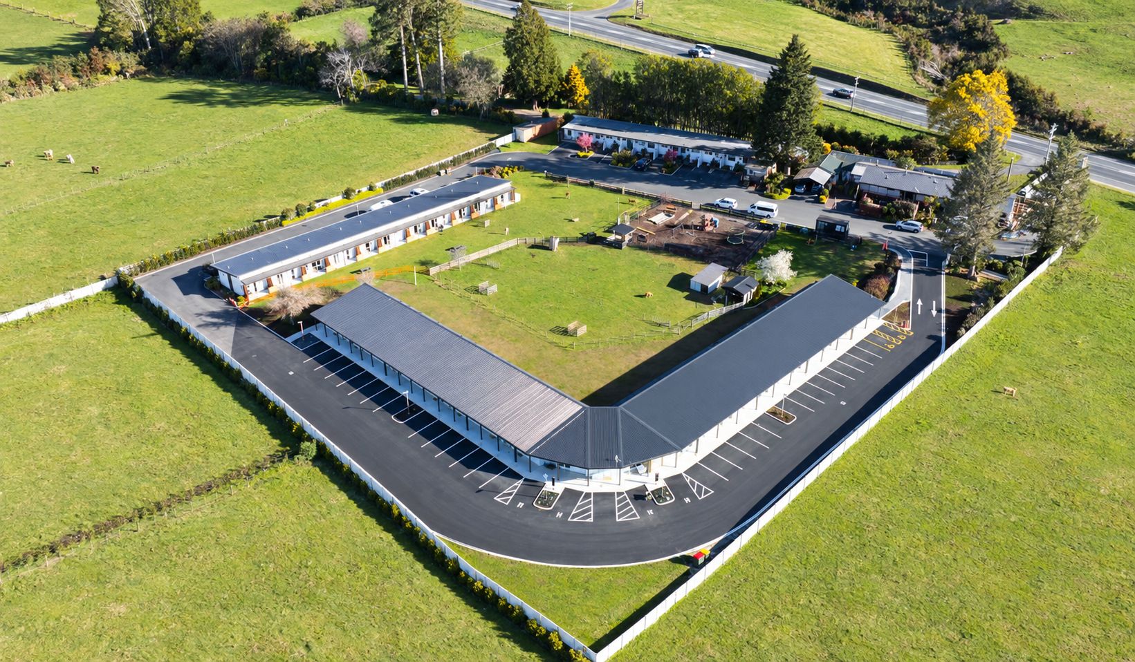 An aerial view of a large parking lot with a building adjacent to it.