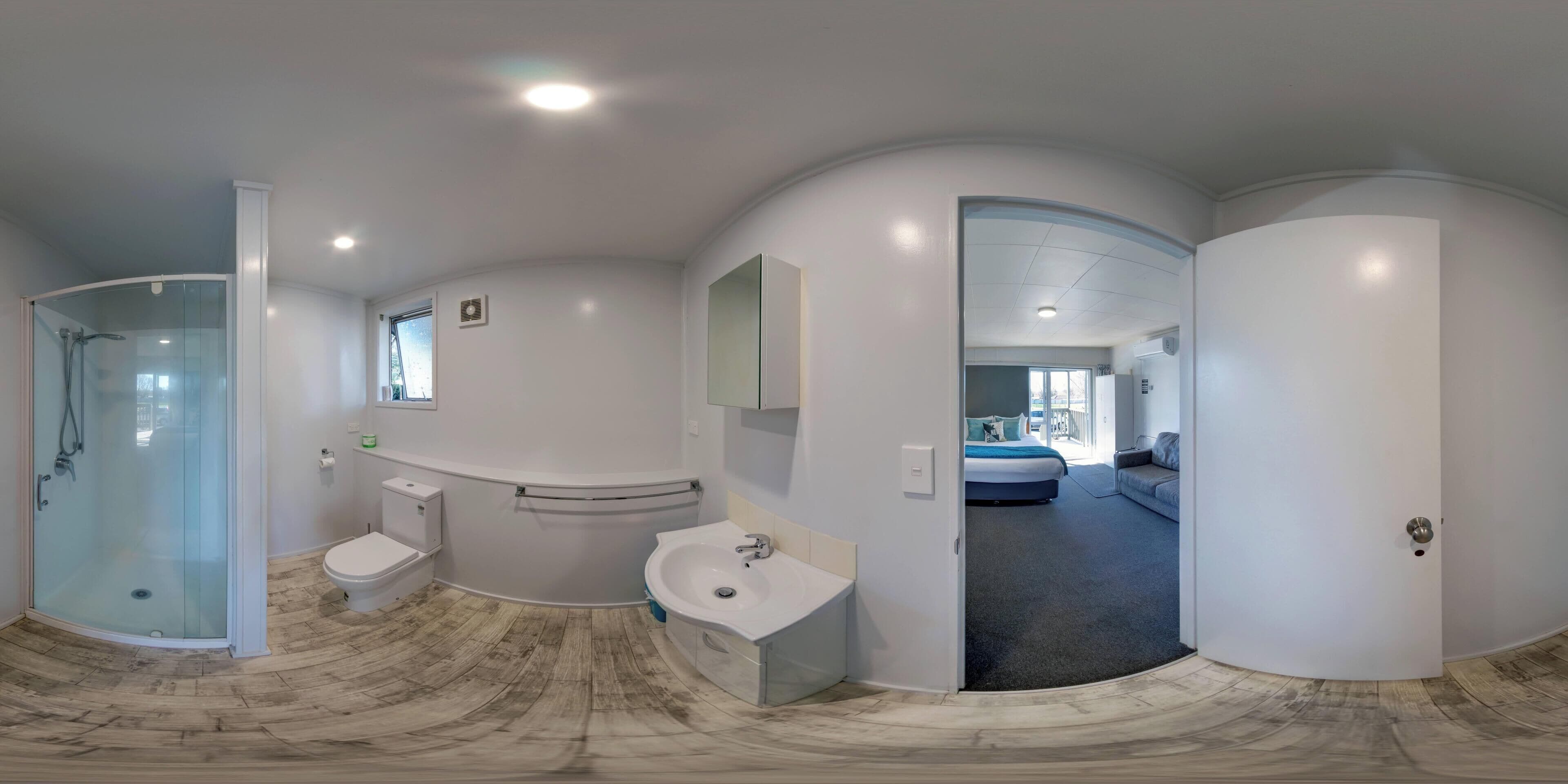 Et moderne badeværelse med bruseniche, toilet og håndvask.