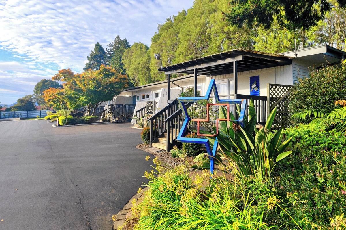 A row of single-story buildings with a blue star-shaped structure in front.