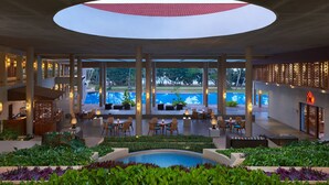 A spacious indoor area with a central circular skylight, multiple seating areas, and a pool visible through large windows. - Cinnamon Bey Beruwala (Beruwala)