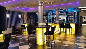 A bar area with checkered flooring, bar stools, and a bar counter with a glass display.