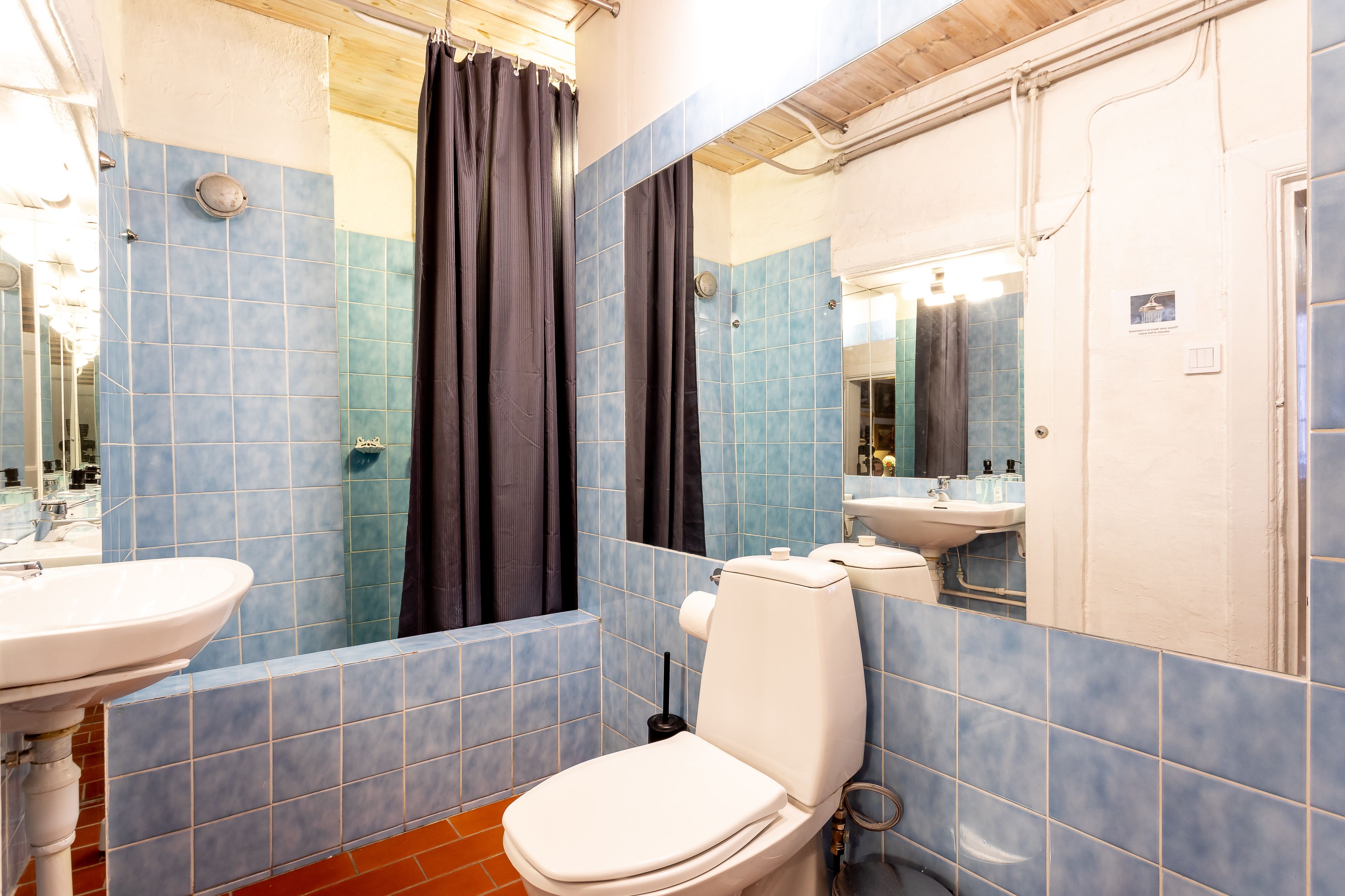 A bathroom with a toilet, sink, and mirror.