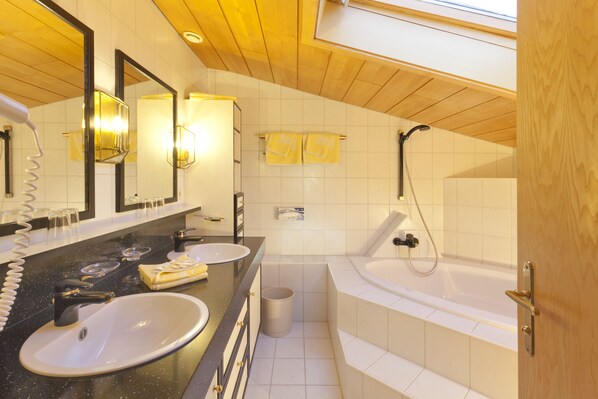 Un baño moderno con lavamanos dobles, un espejo grande y una ducha a ras de suelo.