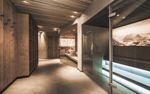 Un intérieur moderne avec un mur en bois, une cabine de douche en verre et une vue sur un paysage montagneux.