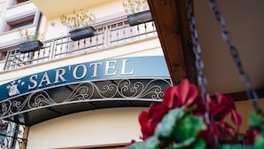 Un letrero de hotel con el nombre 'SAR'OTEL' en una tipografía decorativa.