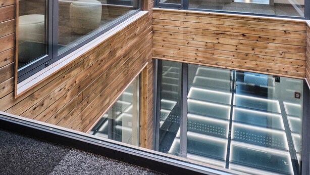 Un interior moderno con paneles de madera y ventanas amplias.