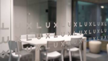 A modern interior with white tables and chairs, a glass wall with 'LUXLUXLUXLUXLUXLUXLUXLUXLUXLUXLUXLUXLUXLUXLUXLUXLUXLUXLUXLUXLUXLUXLUXLUXLUXLUXLUXLUXLUXLUXLUXLUXLUXLUXLUXLUXLUXLUXLUXLUXLUXLUXLUXLUXLUXLUXLUXLUXLUXLUXLUXLUXLUXLUXLUXLUXLUXLUXLUXLUXLUXLUXLUXLUXLUXLUXLUXLUXLUXLUXLUXLUXLUXLUXLUXLUXLUXLUXLUXLUXLUXLUXLUXLUXLUXLUXLUXLUXLUXLUXLUXL