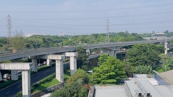 A multi-level highway with overpasses, a bus on the road, and greenery around.