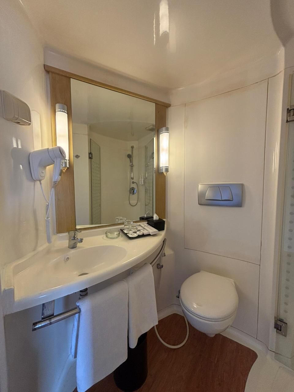 A bathroom with a sink, mirror, towel rack, and toilet.