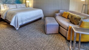 A hotel room with a large bed, a sofa, and a small table. - Courtyard San Marcos (San Marcos)