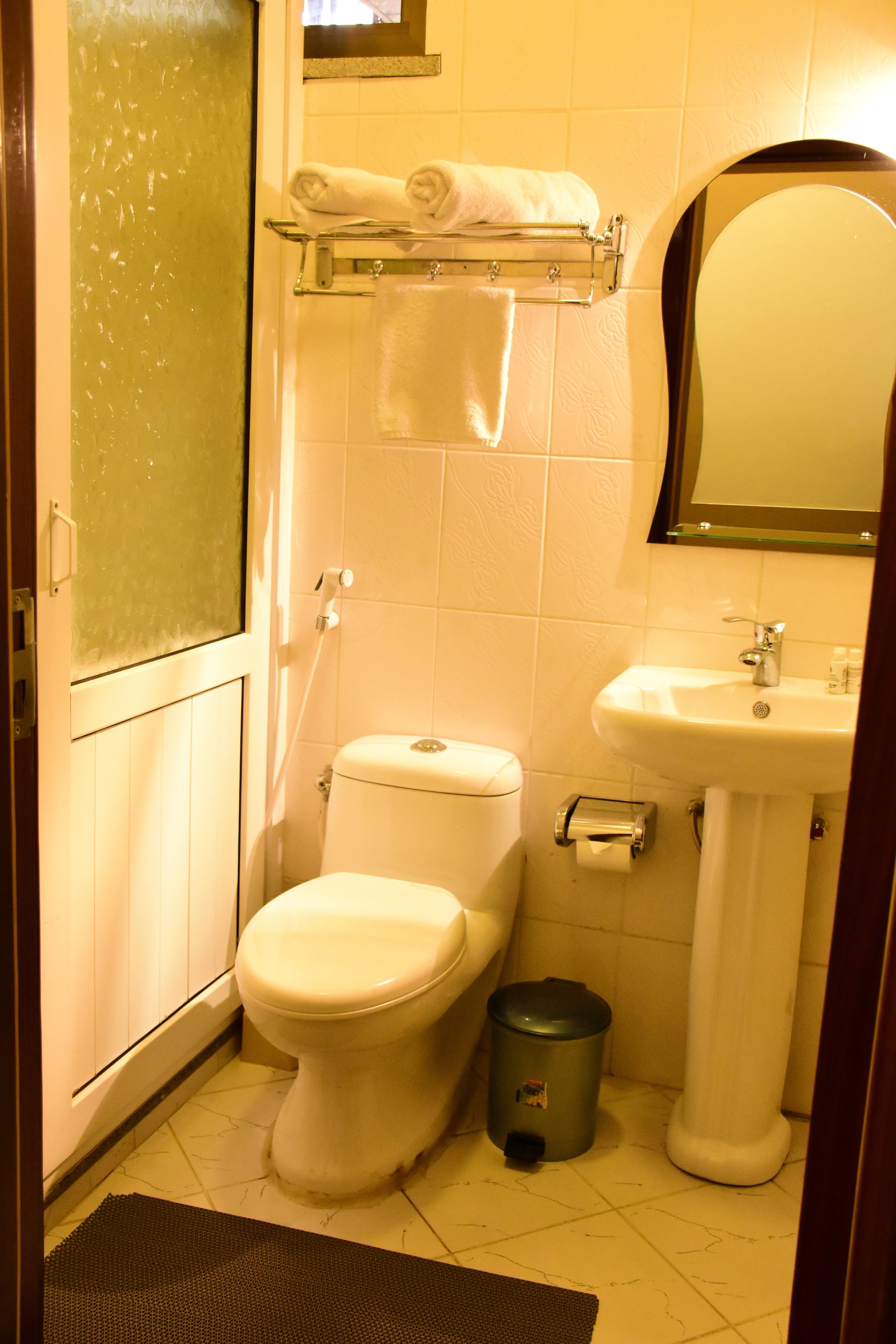 Ein kleines, sauberes Badezimmer mit Toilette, Waschbecken und Handtuchhalter.