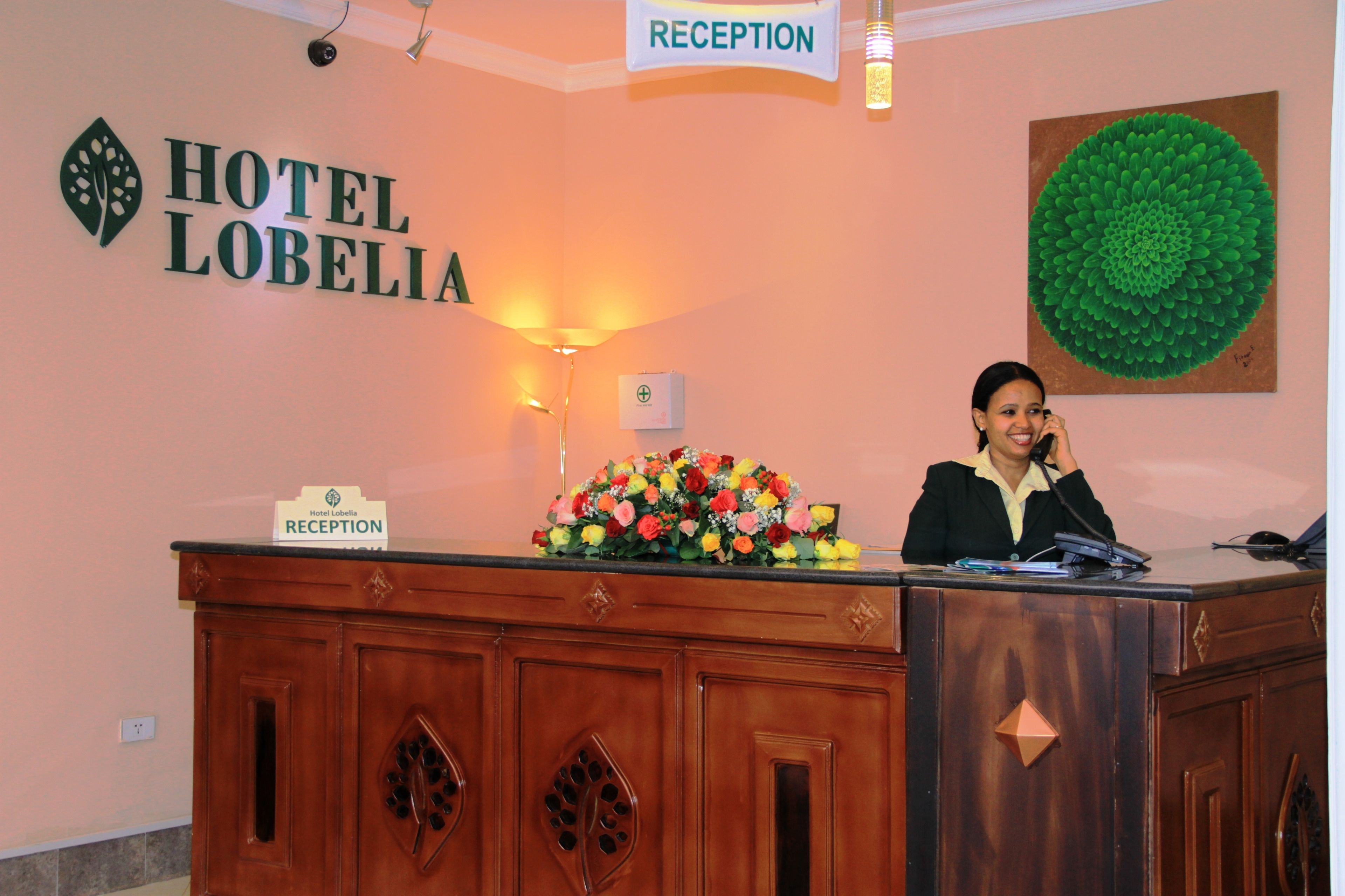 A reception desk at Hotel Lobelia with a sign indicating the reception area.