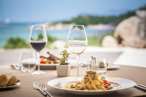 Una mesa dispuesta para una comida, con vista al mar.